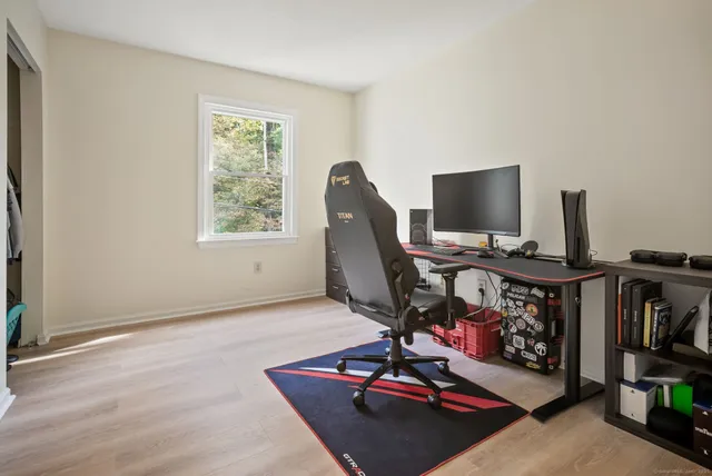 a view of a workspace with furniture and a window