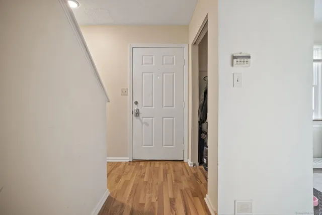 a view of a hallway with wooden floor and entryway