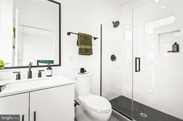 a bathroom with a toilet sink vanity and mirror