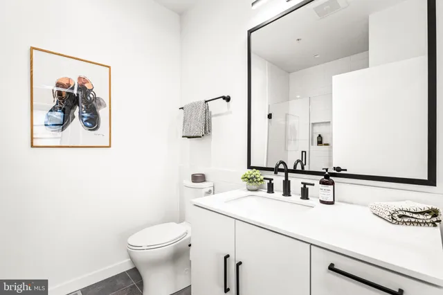 a bathroom with a toilet a sink and mirror