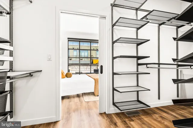 a view of a bedroom with a bed and wooden floor