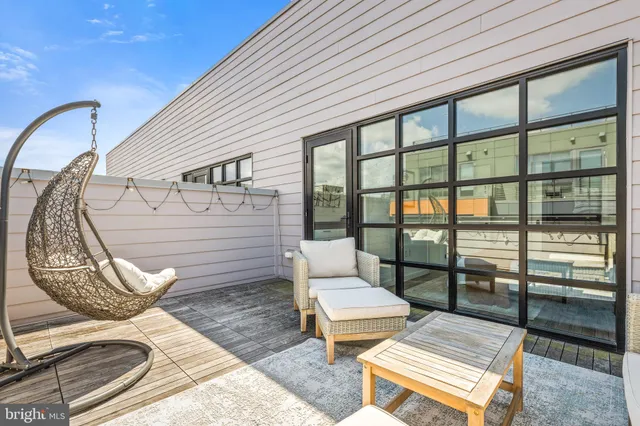 a porch with a bench next to a large window