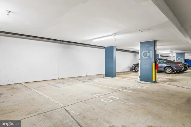 a front view of a building with lot of cars and trees