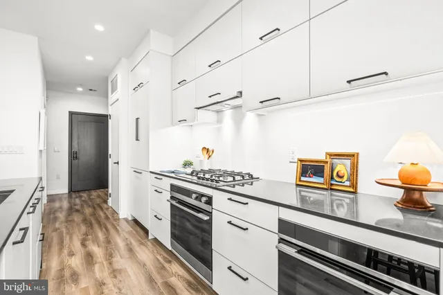 a kitchen with stainless steel appliances a stove a sink and a refrigerator