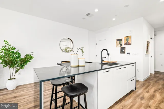 a kitchen with a sink a counter and chairs