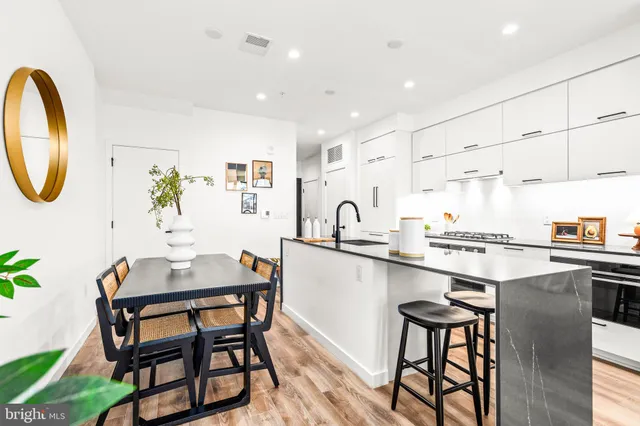 a dining room with stainless steel appliances kitchen island a table and chairs in it