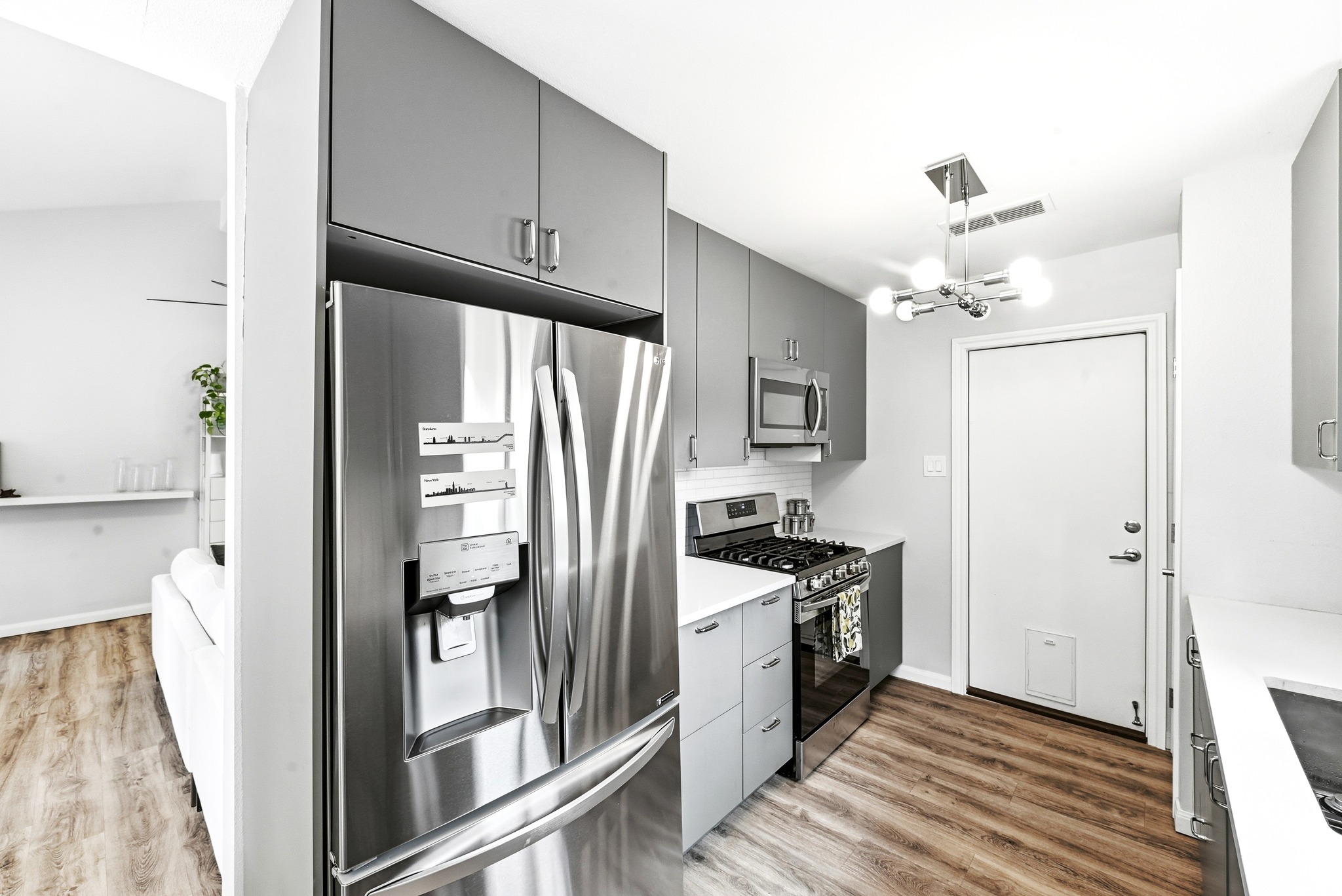 7110 Windrift Way Austin, TX 78745 - Photo 10 of 30 A contemporary kitchen space boasts sleek stainless steel appliances and wood-look flooring.