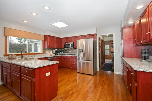 a kitchen with stainless steel appliances granite countertop a stove a refrigerator and a wooden cabinets