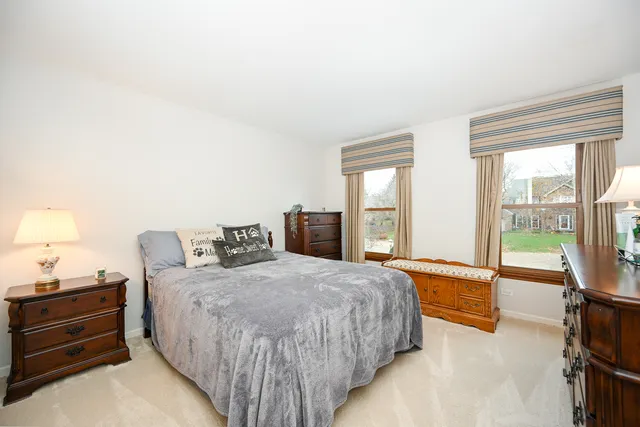 a spacious bedroom with a bed and large windows