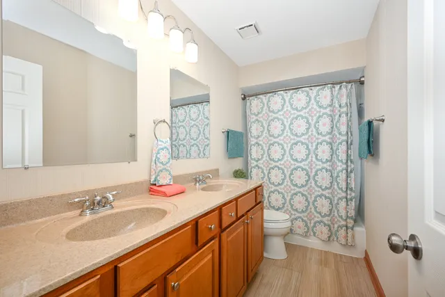 a bathroom with a granite countertop sink a toilet and a mirror