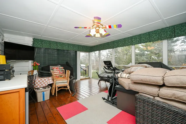a living room with furniture a flat screen tv and a floor to ceiling window
