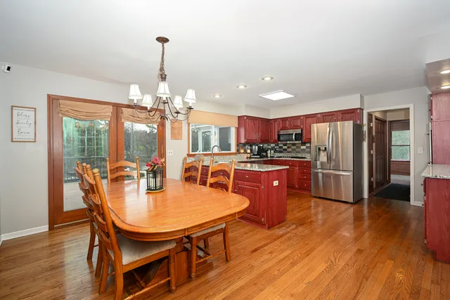 a dining room with furniture a chandelier and wooden floor