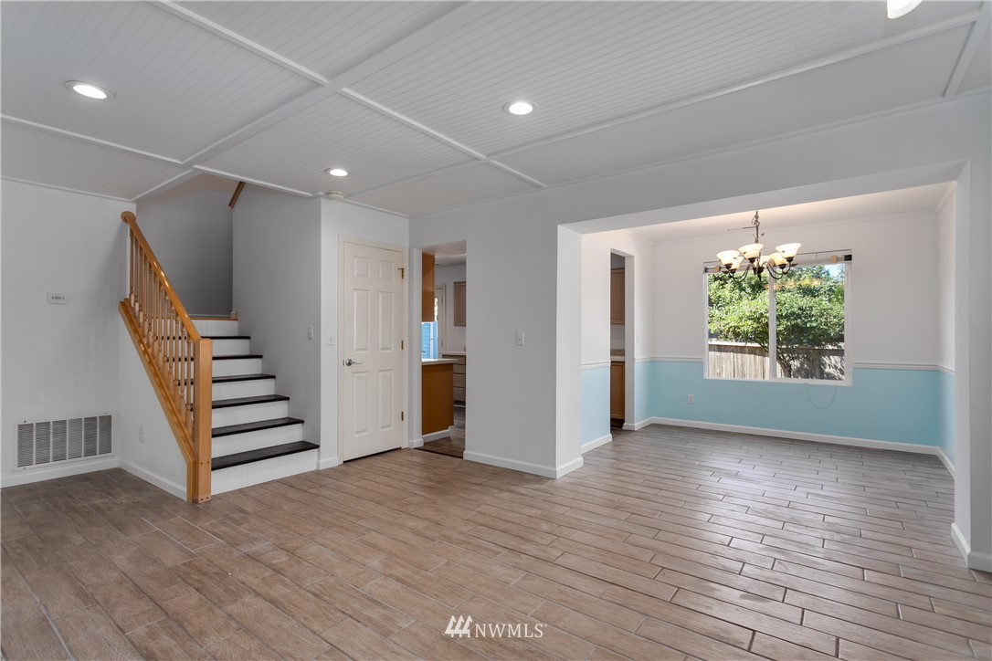 507 211th Place Southeast Bothell, WA 98021 - Photo 3 of 26 an empty room with wooden floor staircase and windows