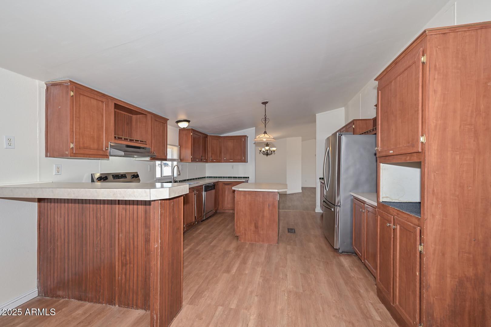 36608 West Lower Buckeye Road Tonopah, AZ 85354 - Photo 16 of 39 a large kitchen with stainless steel appliances wooden floors and wooden cabinets