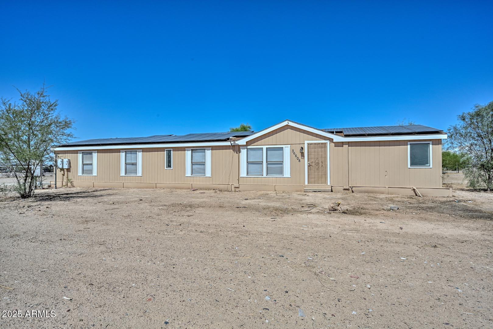 36608 West Lower Buckeye Road Tonopah, AZ 85354 - Photo 2 of 39 a front view of a house with a dirt road