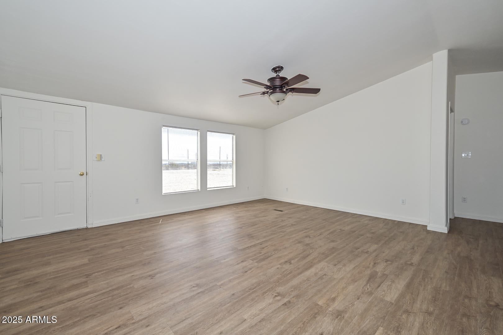 36608 West Lower Buckeye Road Tonopah, AZ 85354 - Photo 8 of 39 a view of empty room with wooden floor and fan