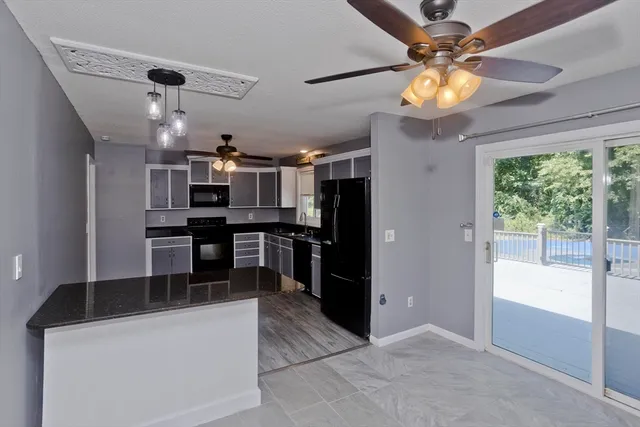 a kitchen with stainless steel appliances kitchen island granite countertop a refrigerator and a stove top oven