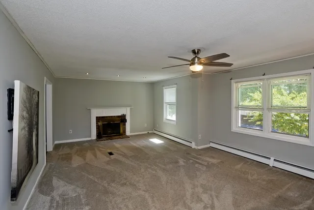 an empty room with windows and ceiling fan