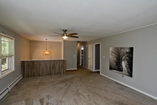 an empty room with windows cabinet and front door
