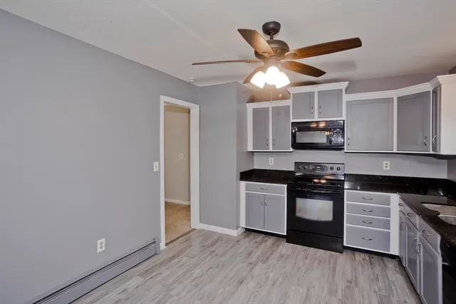 a kitchen with granite countertop a stove a sink and a refrigerator