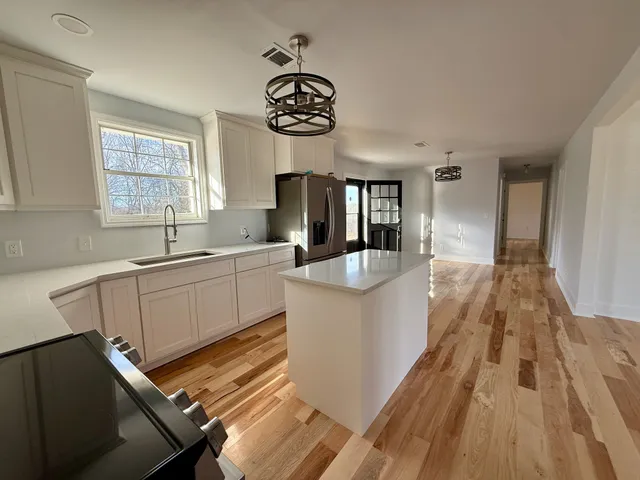 a view of a kitchen with an entryway and wooden floor