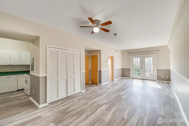 a view of a livingroom with wooden floor and a ceiling fan