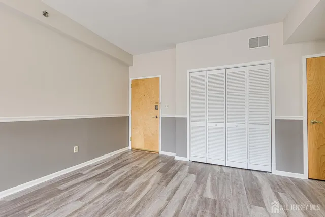 an empty room with closet and wooden floor