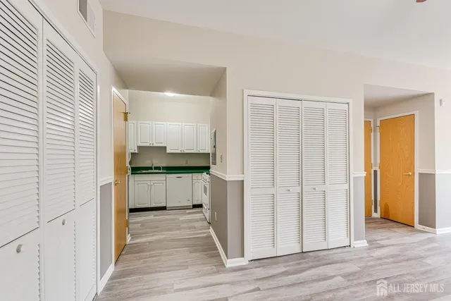 a kitchen with a refrigerator and white cabinets