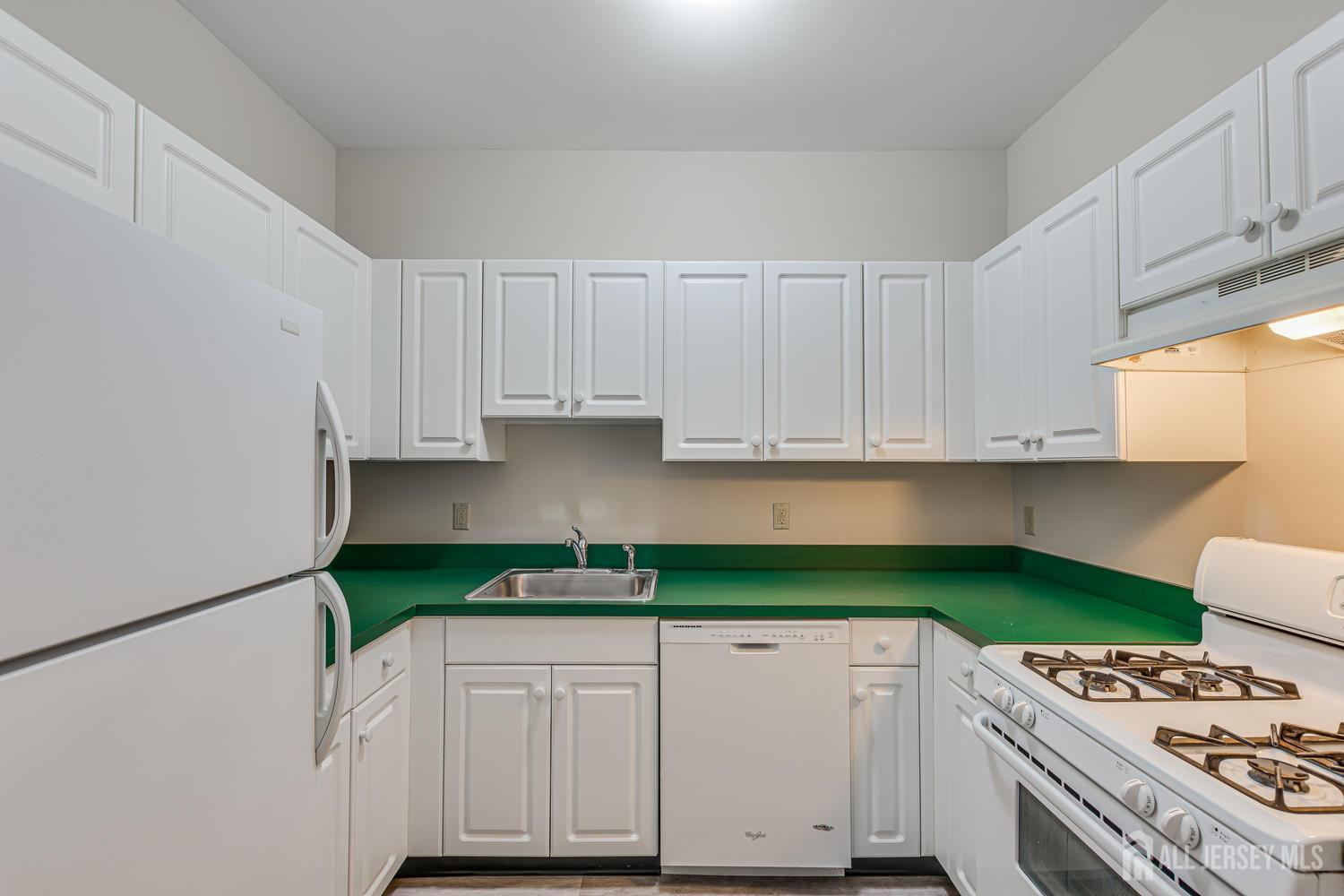 160 Durham Avenue, Unit 305 Metuchen, NJ 08840 - Photo 10 of 39 a kitchen with white cabinets and appliances