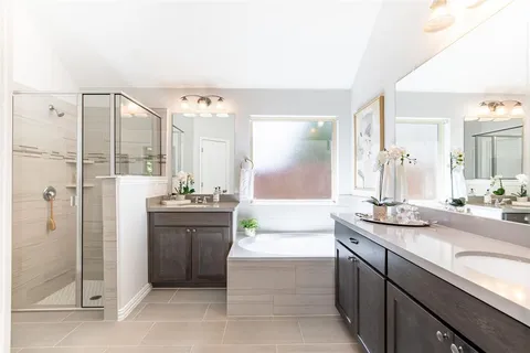 a bathroom with a granite countertop sink a mirror and shower