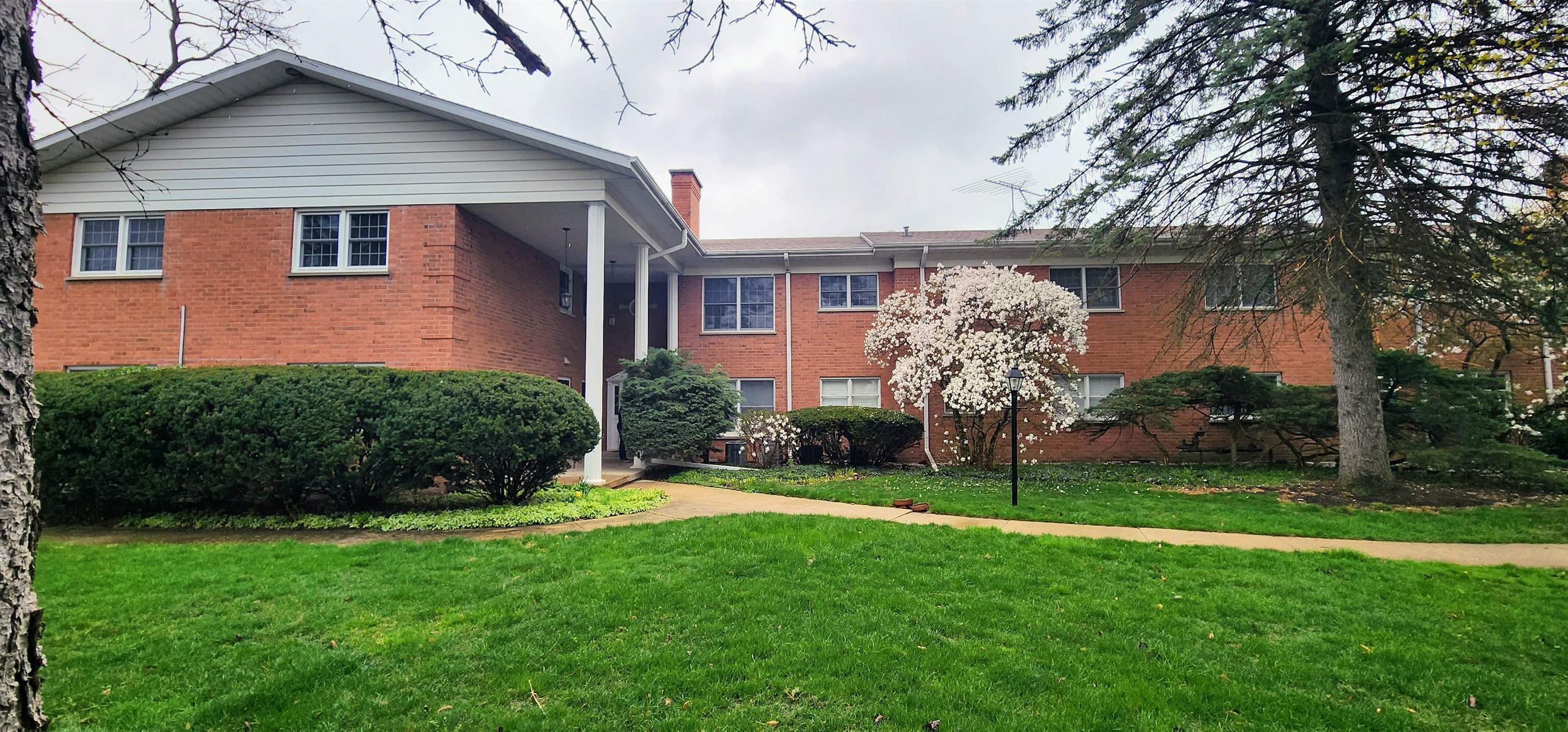 1450 Wing Street Elgin, IL 60123 - Photo 1 of 36 a front view of a house with a garden and plants