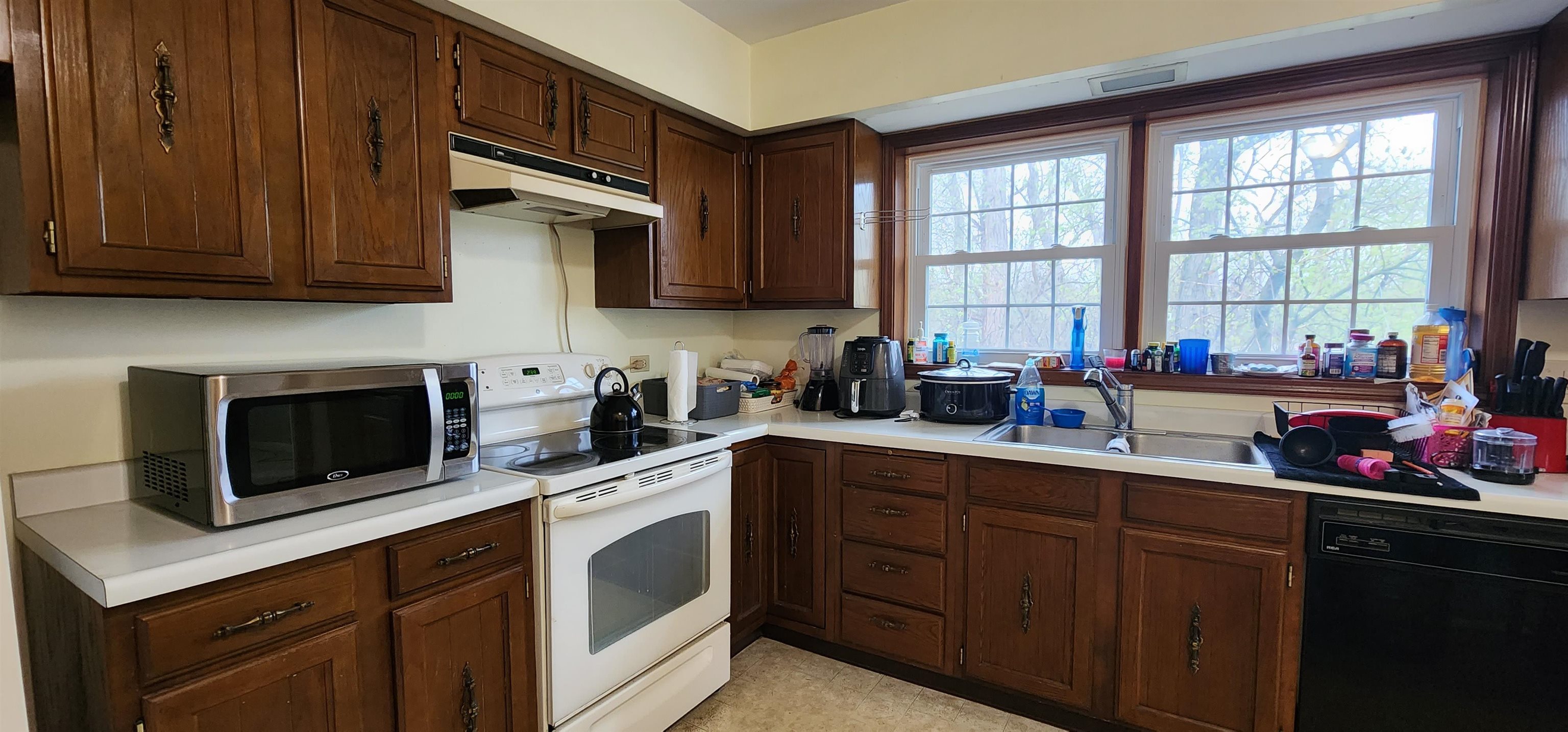1450 Wing Street Elgin, IL 60123 - Photo 10 of 36 a kitchen with stainless steel appliances a sink a stove a microwave cabinets and a window
