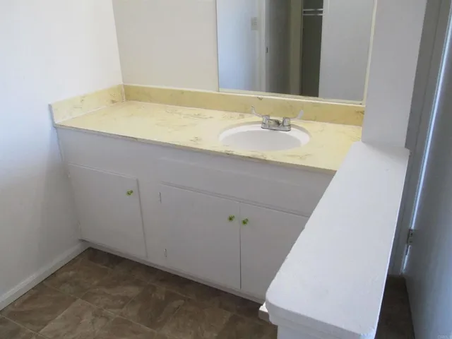 a bathroom with a granite countertop sink and a mirror