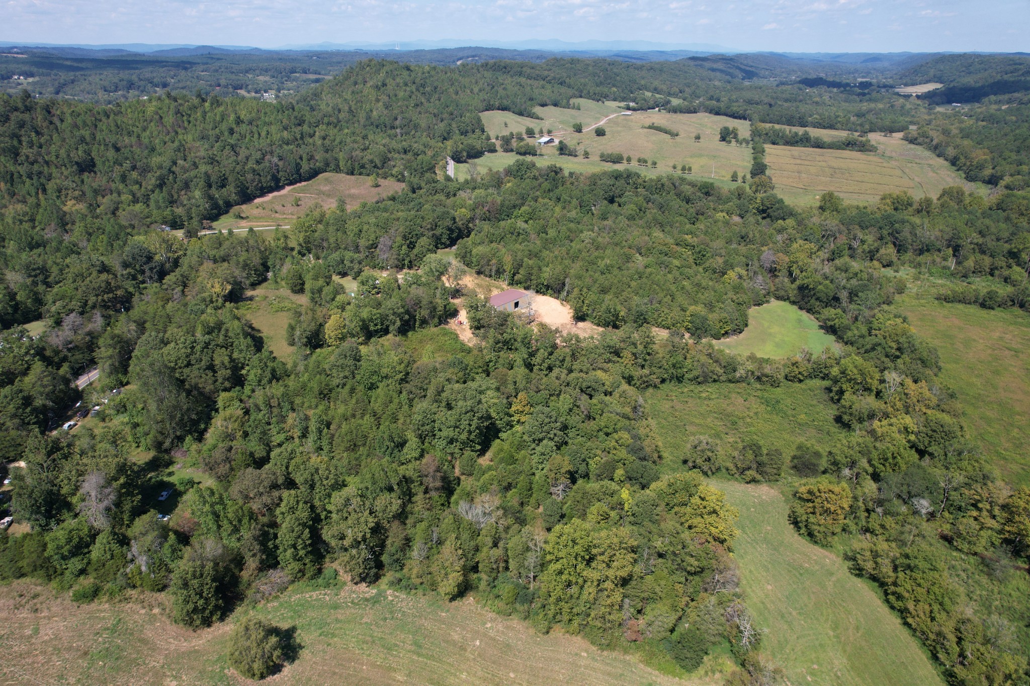 703 Sweetwater Road Philadelphia, TN 37846 - Photo 9 of 34 an aerial view of a houses with a lush green hillside