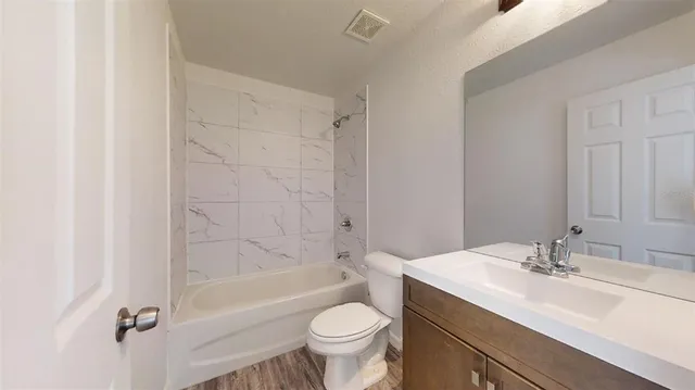 a bathroom with a sink toilet mirror and shower