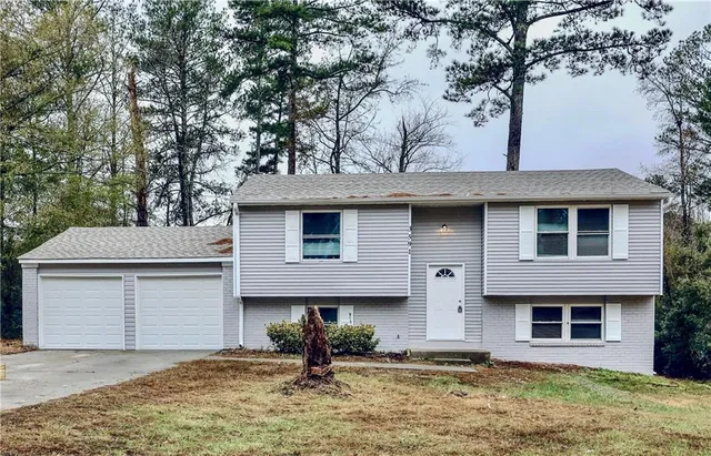 a front view of a house with a yard garage and outdoor seating