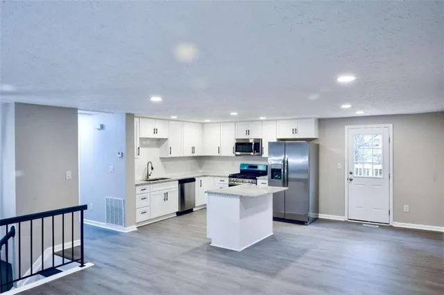 a kitchen with stainless steel appliances a refrigerator and a stove top oven