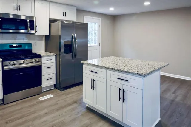 a kitchen with white cabinets and stainless steel appliances
