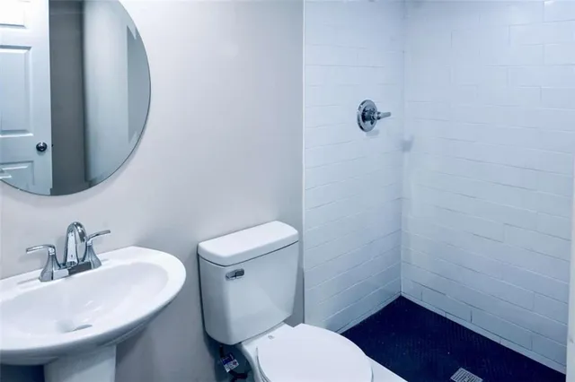 a bathroom with a sink a toilet and a mirror