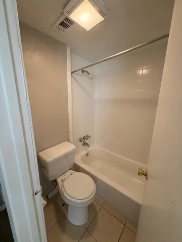 a bathroom with a granite countertop sink a toilet and a shower