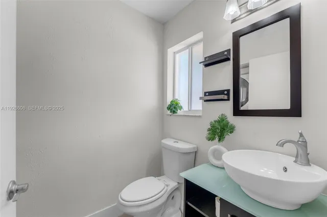 a bathroom with a sink a toilet and mirror