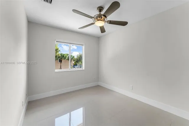 an empty room with a window and a fan