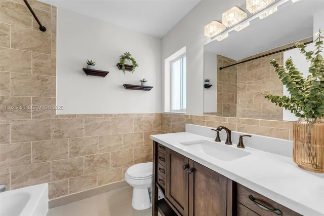 a bathroom with a sink a toilet and mirror