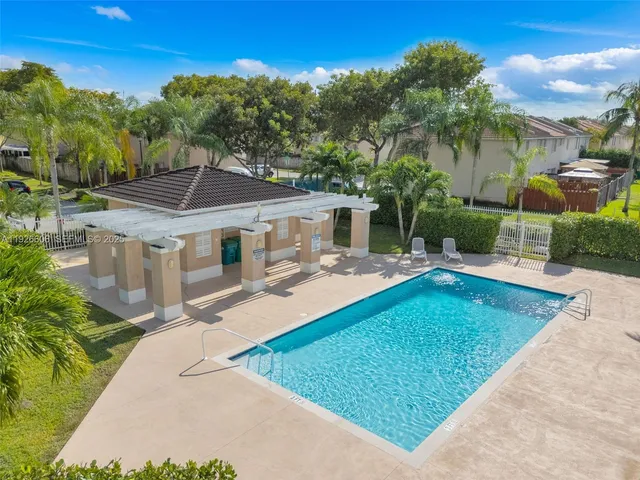 an aerial view of a house with swimming pool garden and patio