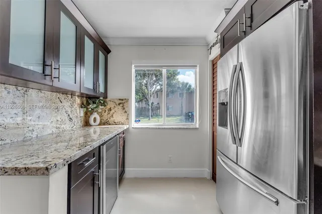 a kitchen with stainless steel appliances granite countertop a refrigerator and a sink