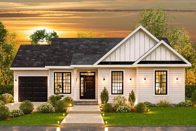 a view of a house with brick walls plants and large tree