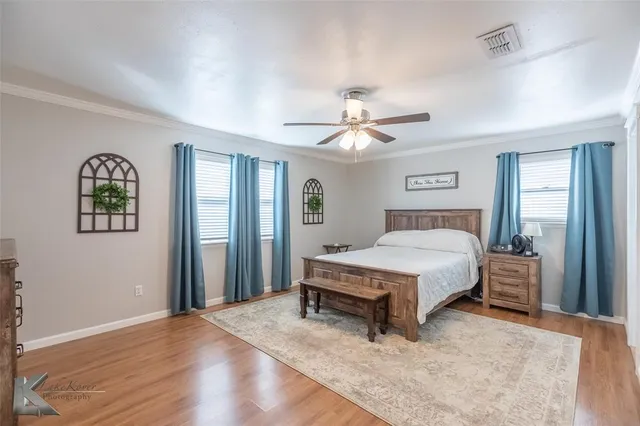 a spacious bedroom with a bed and a chandelier