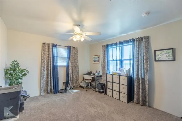 a view of a livingroom with furniture and a ceiling fan