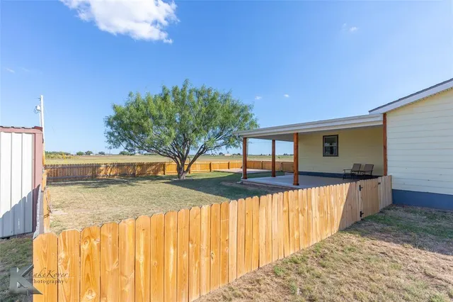 a view of a house with a backyard and a patio