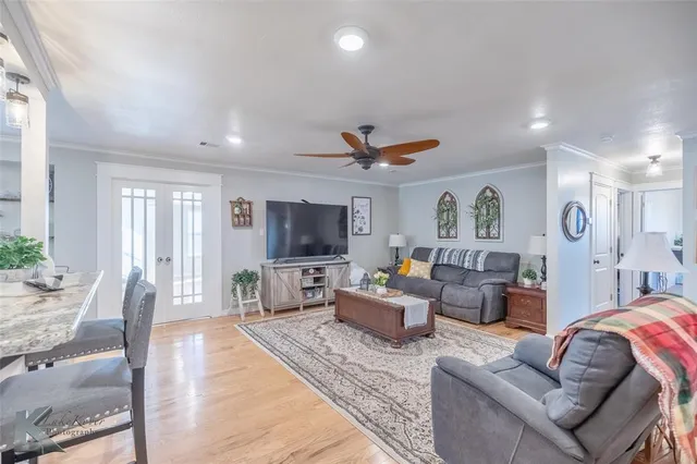 a living room with furniture a flat screen tv and a large window